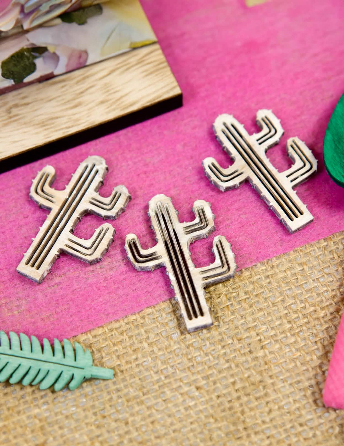 Primer plano de los motivos grabados de los confetis cactus para decoración en madera natural