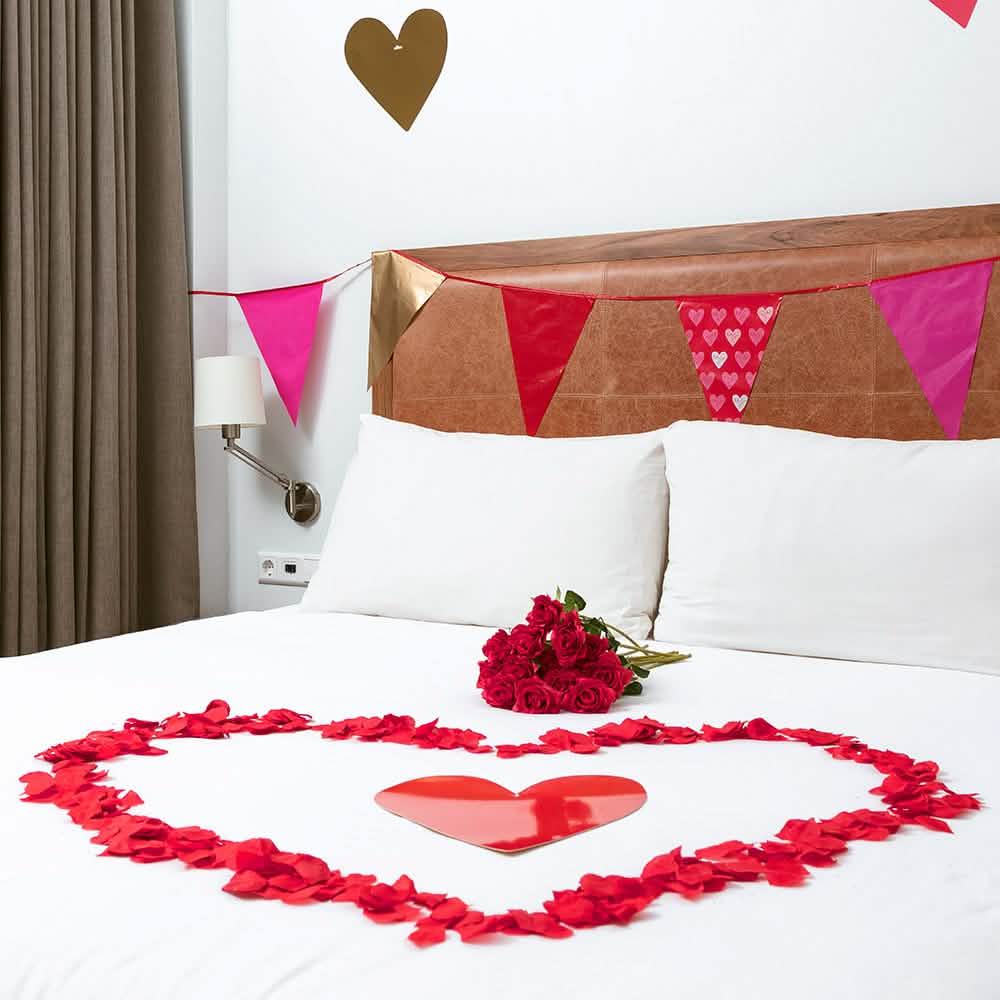 Corazón formado sobre una cama de pétalos de rosa para decoración de fiesta