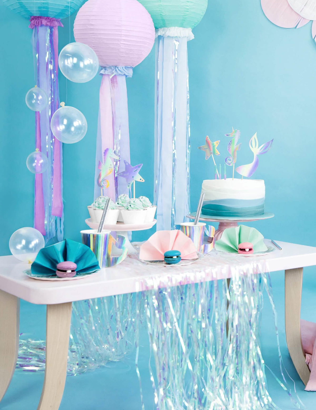 Vista general de la mesa de fiesta de los cake toppers sirenas