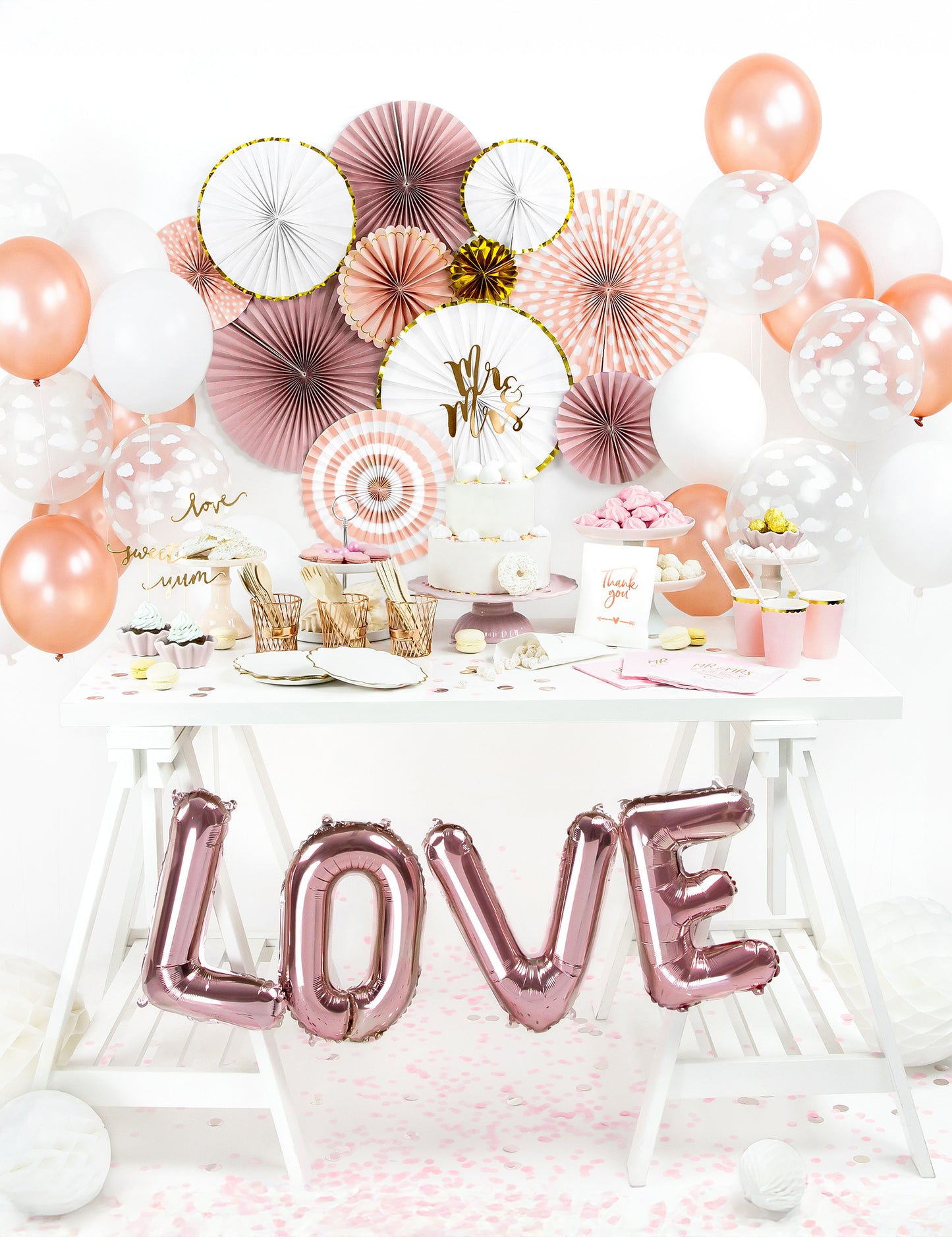 Vue d'ensemble sur une table de fête des 3 rosaces en papier blanches et dorées pour décoration