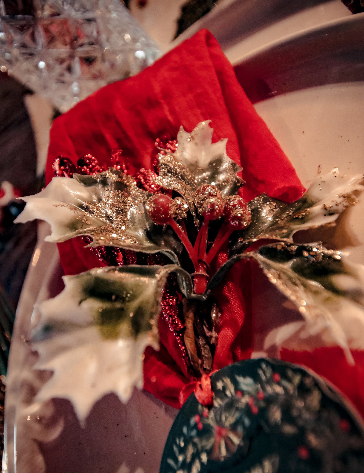 Gros plan sur les paillettes et baies rouges des branches de houx sur tige de Noël