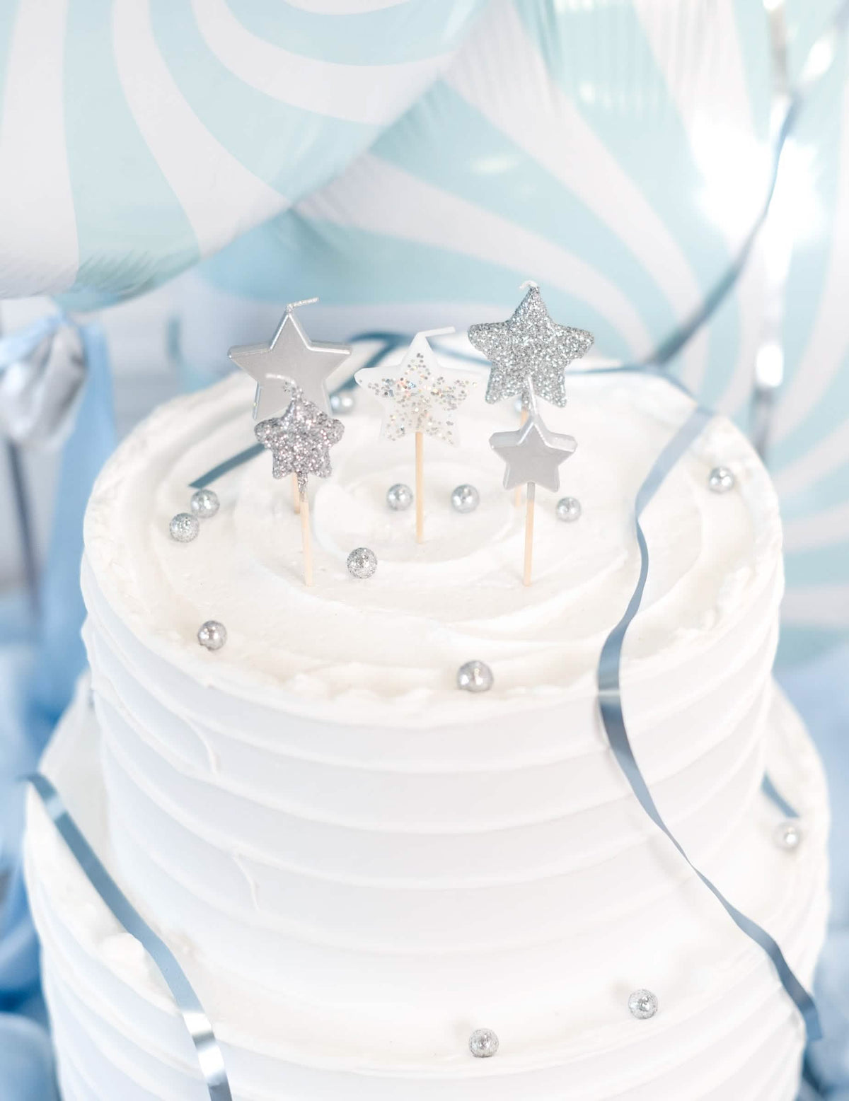 Escena sobre un pastel de velas estrellas sobre pico degradado plateado y con purpurina