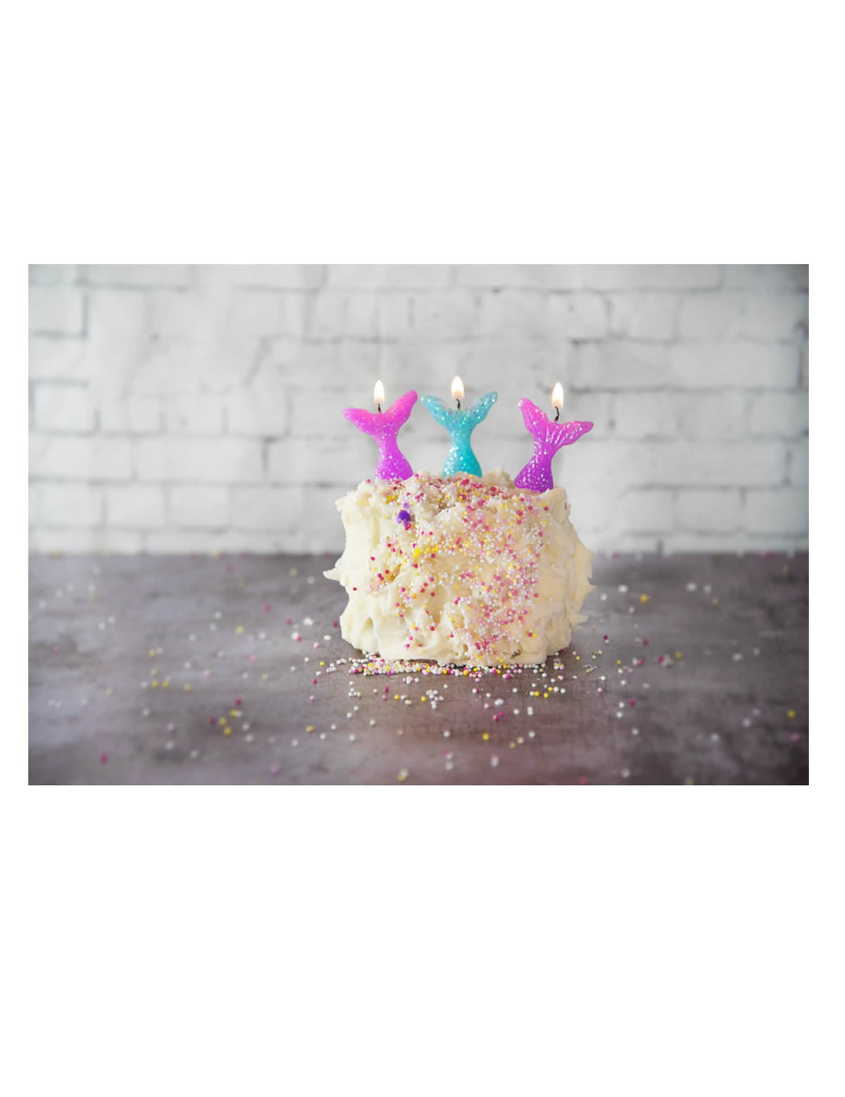 Escena sobre un pastel con velas de cola de sirenas