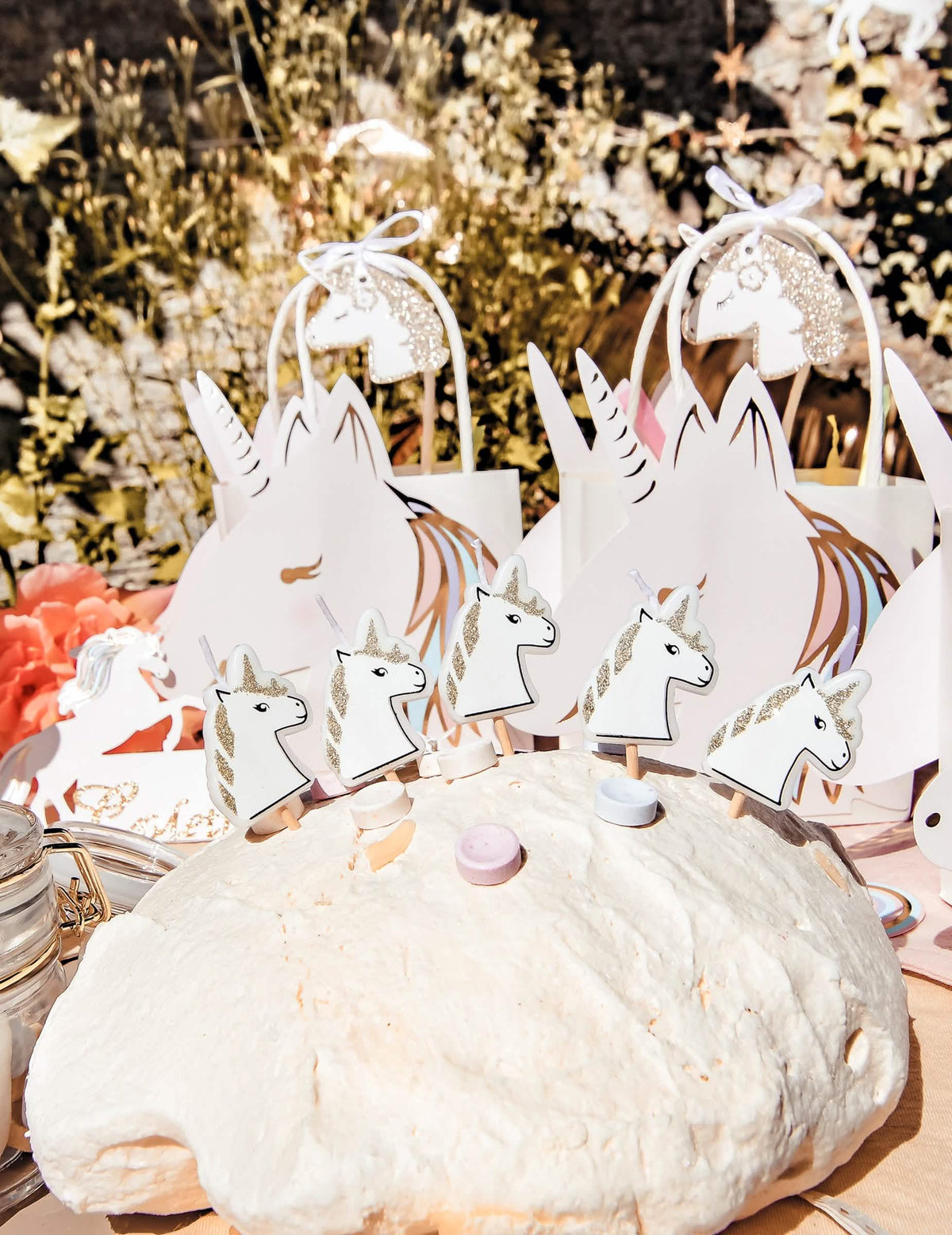Mise en situación sobre un pastel con velas en pico unicornio lentejuelas champagne