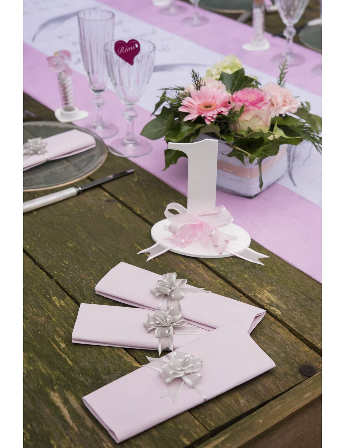 Escenificación sobre servilletas de mesa con mini lazos de organza para tirar para decoración rosas