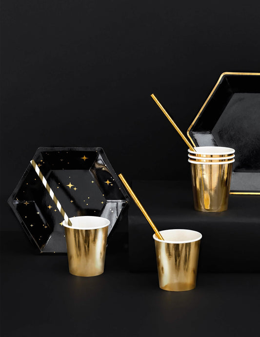 Mise en scène des assiettes en carton hexagonales étoiles pour fête noires et dorées