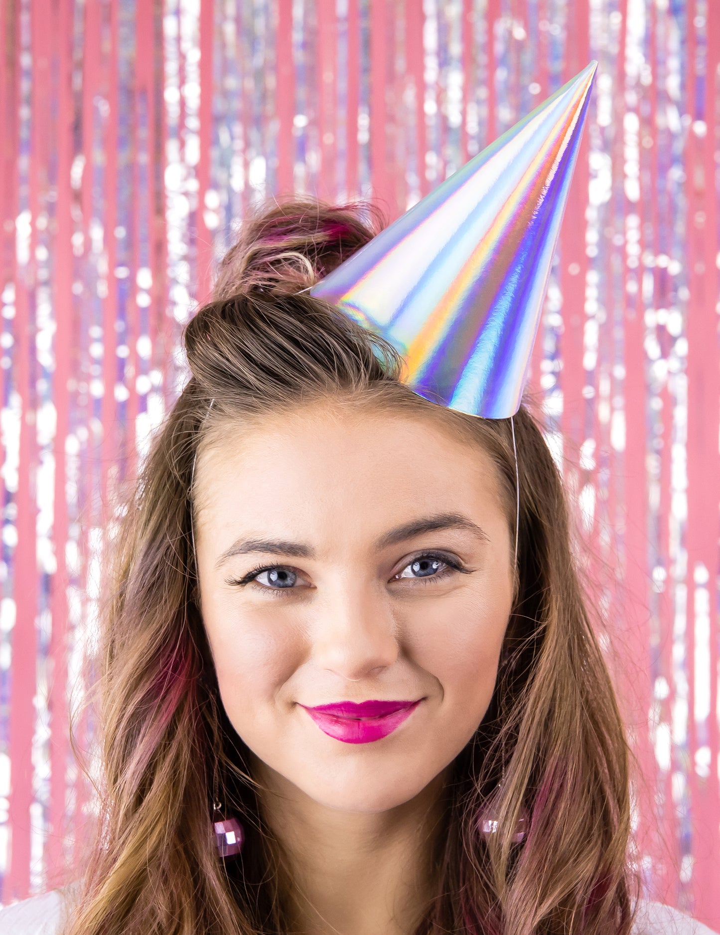 Porté par un modèle du chapeau de fête pour anniversaire iridescent