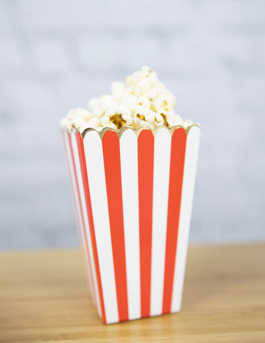 Vue d'une boîte remplie de popcorn des boîtes à popcorn à rayures pour fête rouges et blanches avec liseré doré