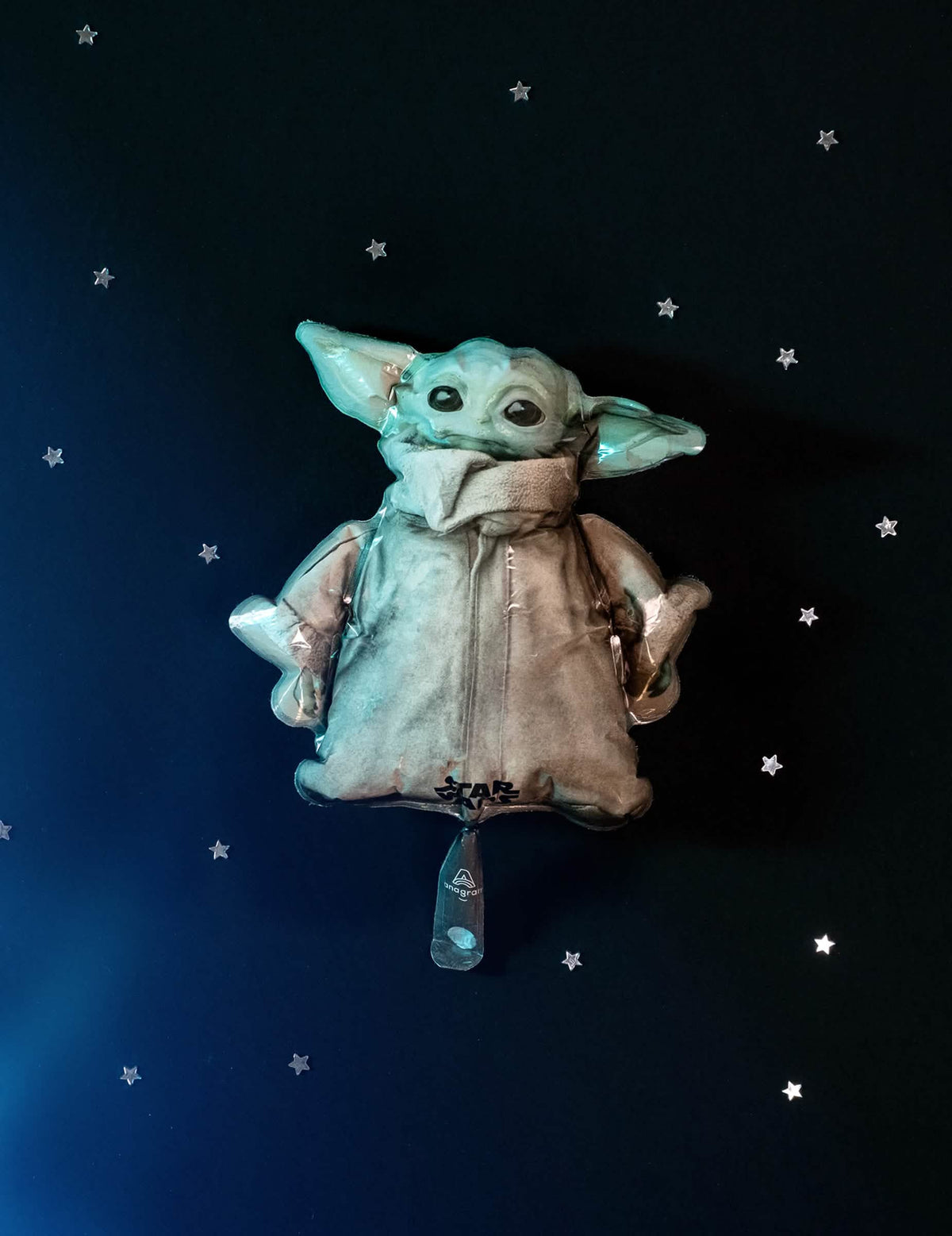 Vista frontal sobre fondo estrellado del globo de aluminio bebé Yoda The Mandalorian