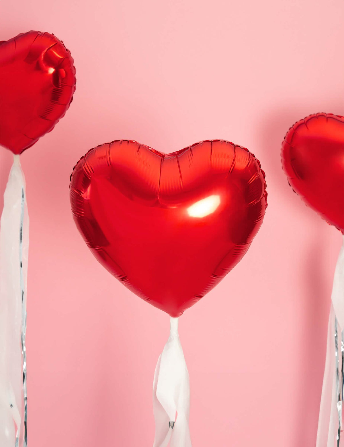 Mise en situation sur fond rose du ballon aluminium coeur pour fête rouge métallisé