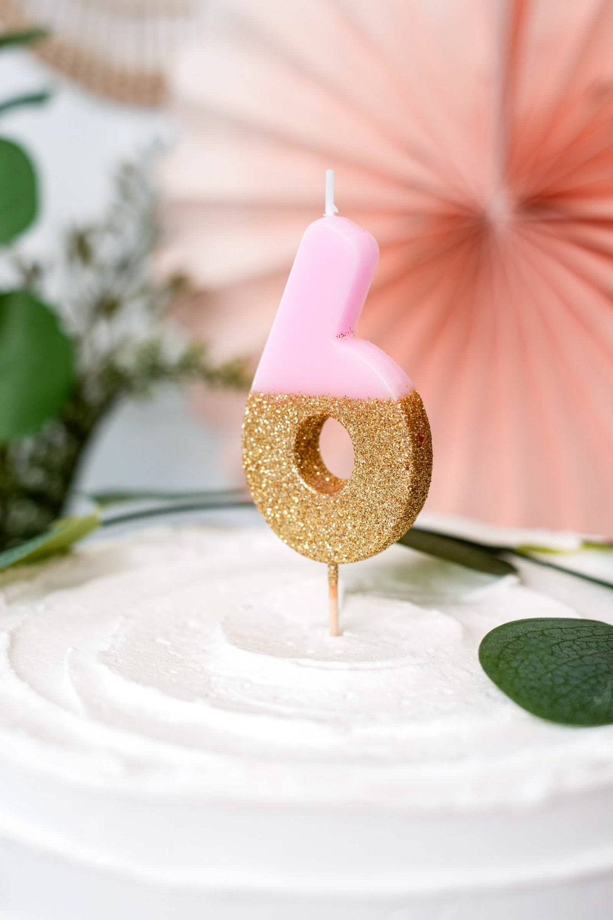 Primer plano de la vela sobre pincho número 6 para pastel rosa y dorado con purpurina