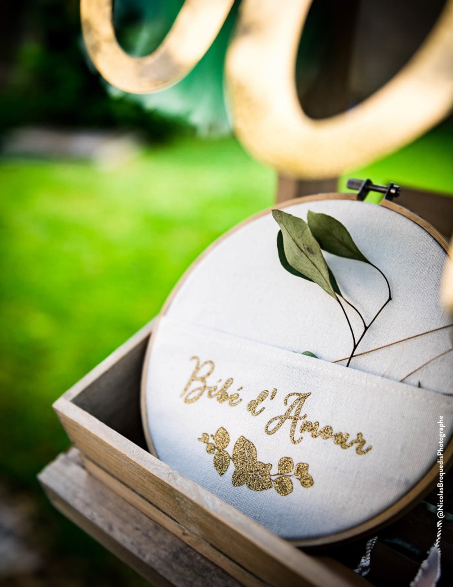 Gros plan sur l'inscription pailletée du cadre pochette bébé d'amour