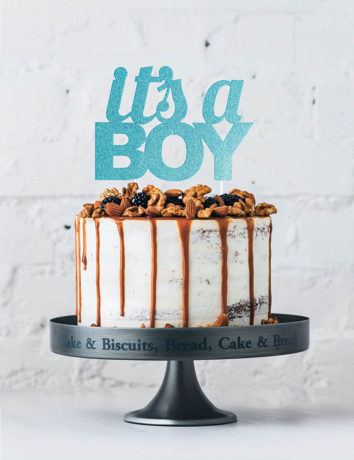 Escena sobre un pastel con el cake topper «it's a boy» para baby shower