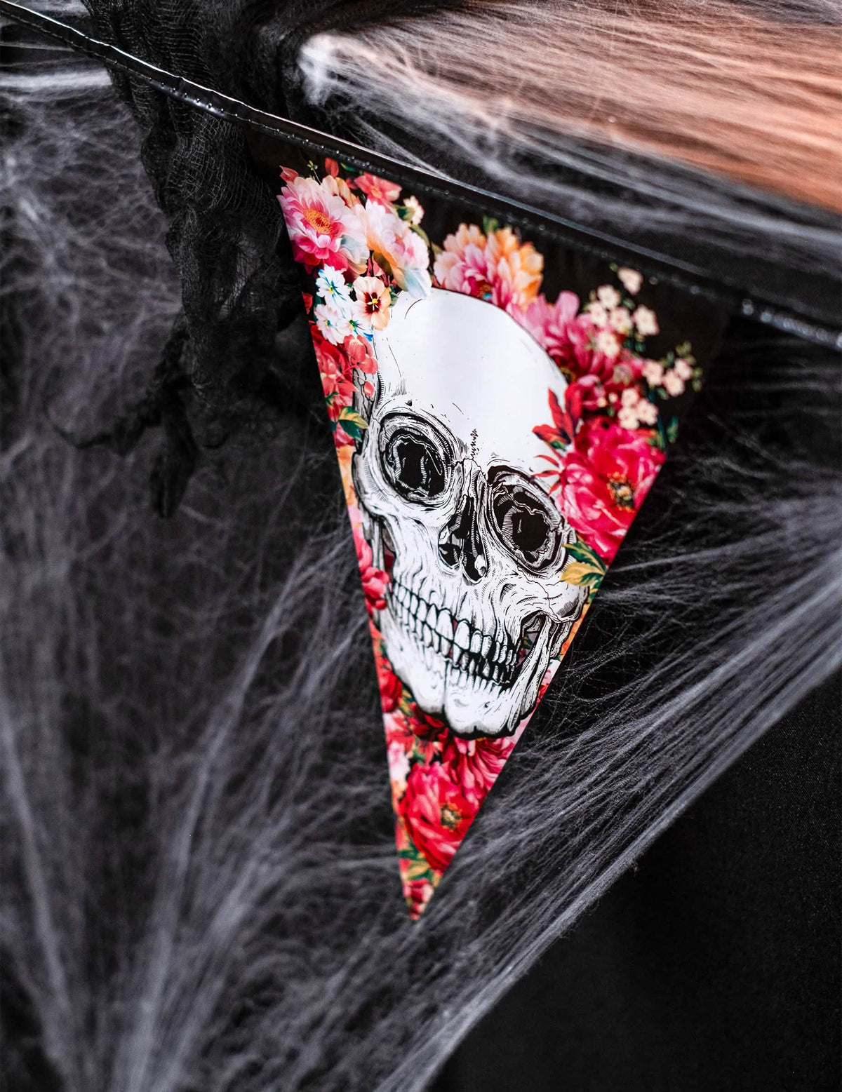Detalle del motivo de calavera y flores de la guirnalda de plástico esqueleto floral