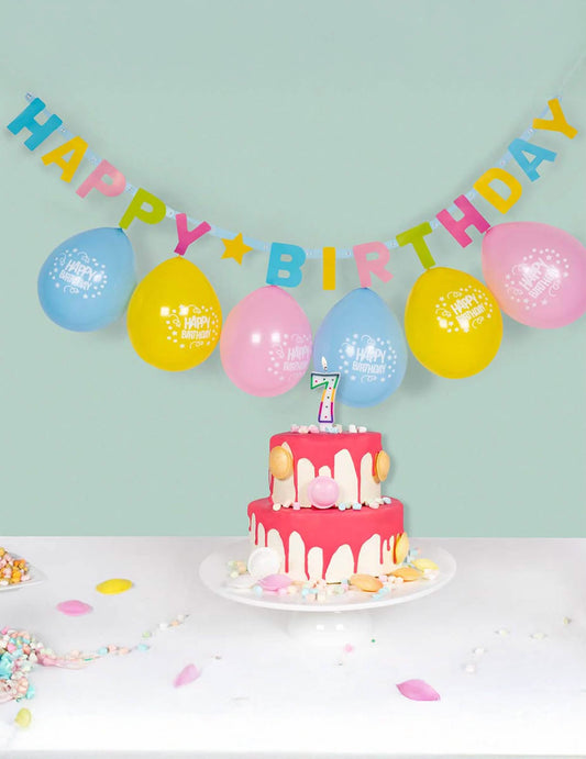 Mise en scène avec gâteau et ballons de la guirlande de lettres Happy Birthday
