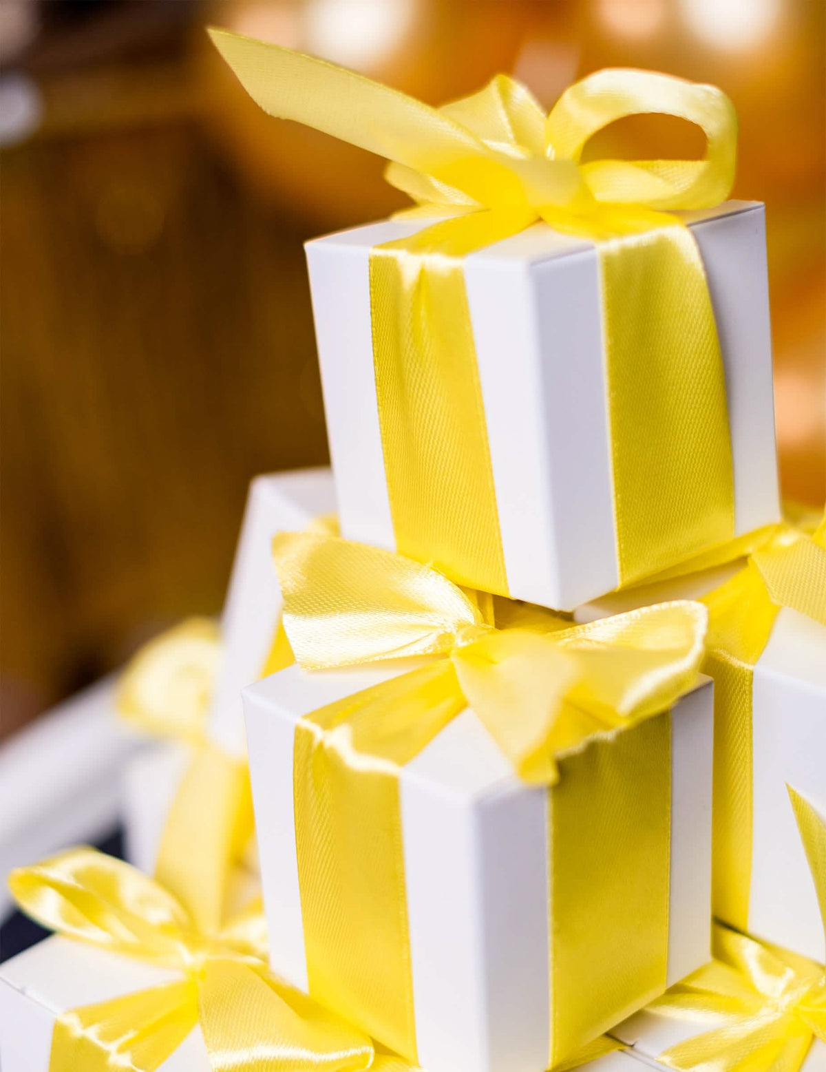 Pilas de cajas de regalo decoradas con cinta de satén amarillo limón para decoración de fiesta