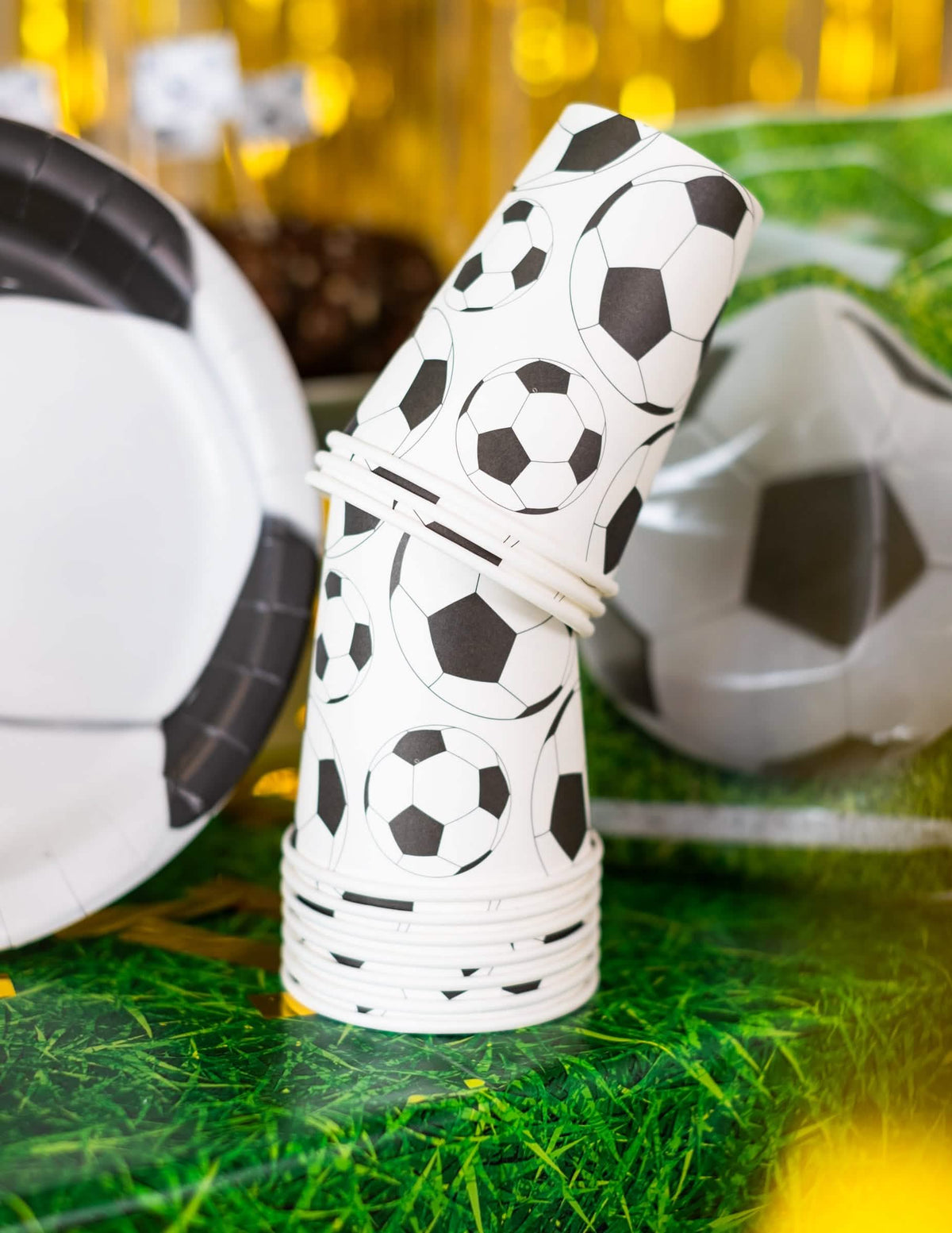 Puesta en escena con plato a juego del vaso de cartón balón de fútbol