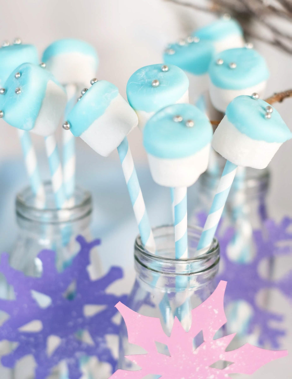 Utilización en palitos para malvaviscos de las pajitas de cartón rayadas azul pastel