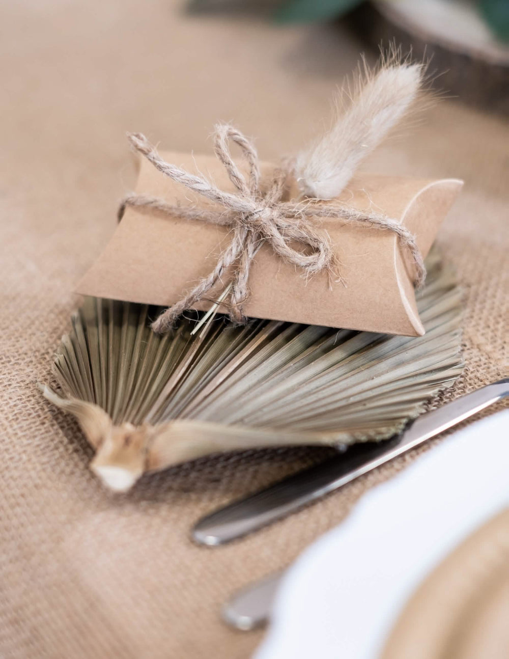 Detalle de la decoración con hoja de palmera de las pequeñas cajas kraft para fiesta