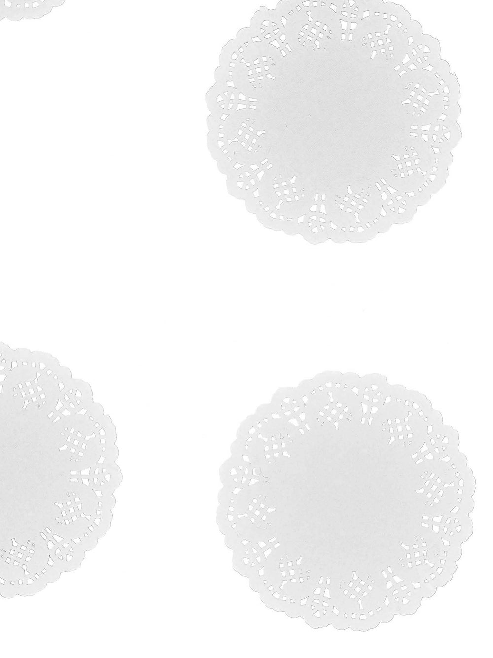 Vista de varios ejemplares de los pequeños manteles individuales de papel de encaje blanco