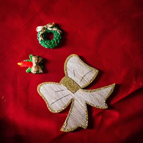 Détail des motifs pailletés or des 12 nœuds en bois de Noël