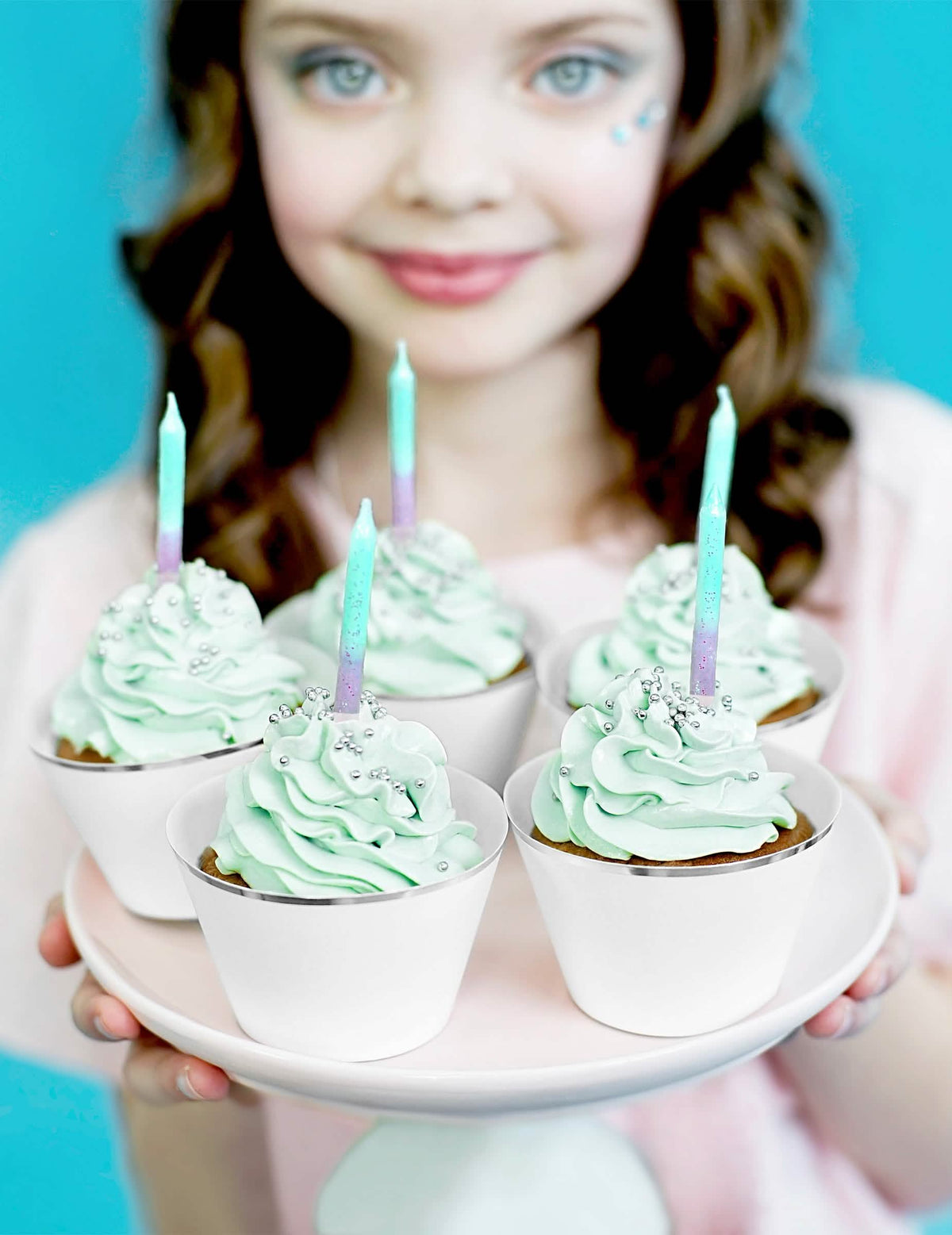 Escenificación sobre cupcakes y velas de cumpleaños iridiscentes