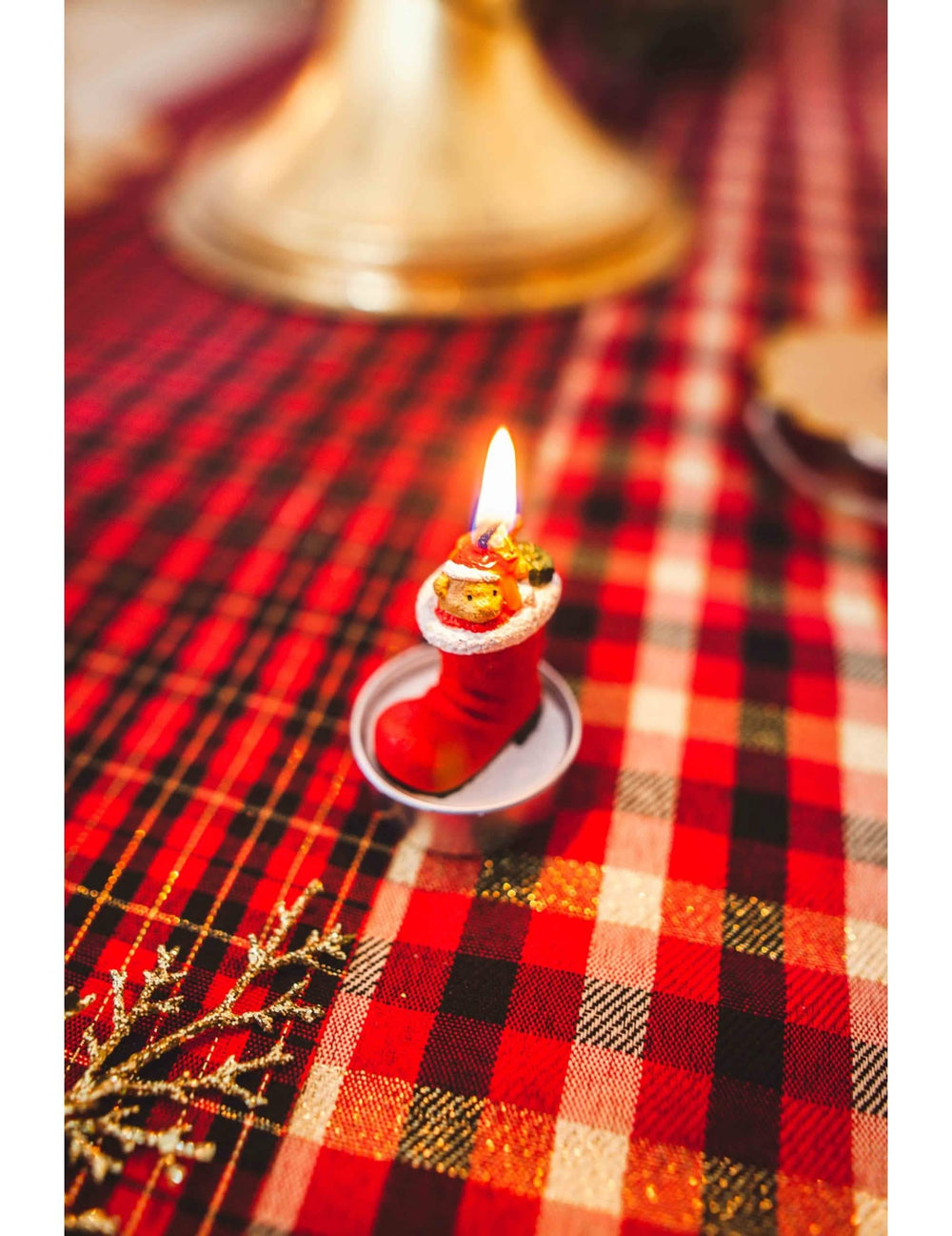 Zoom sobre la vela encendida de las 3 velas bota de papá noel con osito