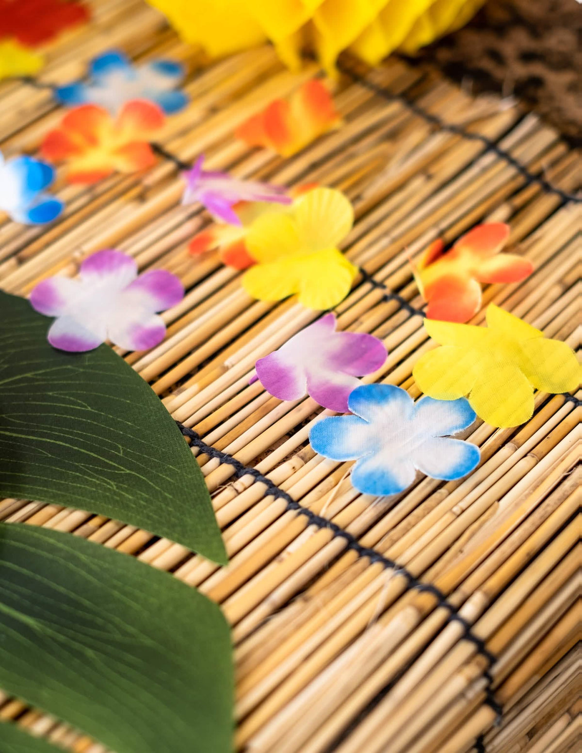 Escena sobre una esterilla de bambú con flores decorativas de hawái