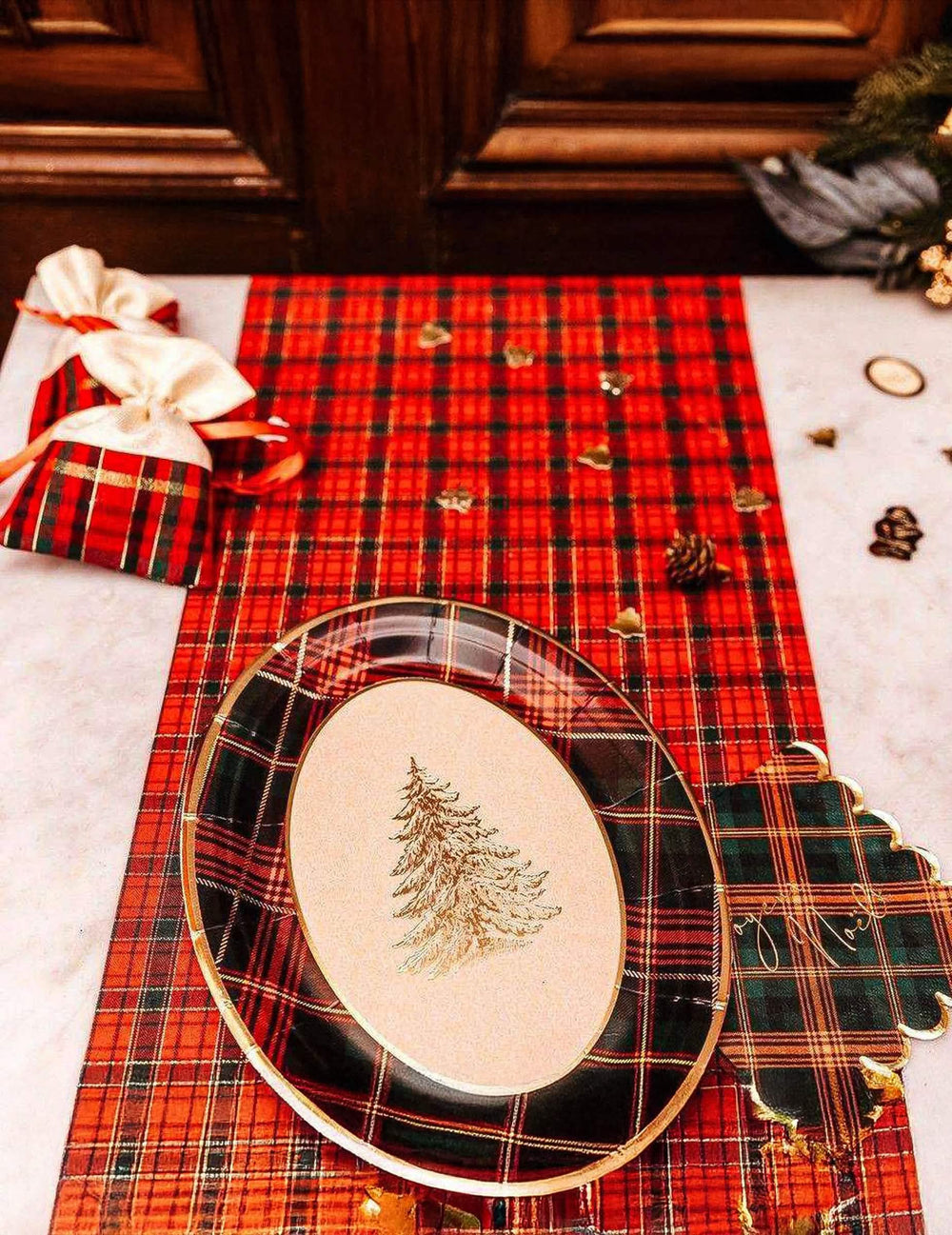 Mise en scène avec décoration de fête et pochons du plateaux en carton tartan de Noël