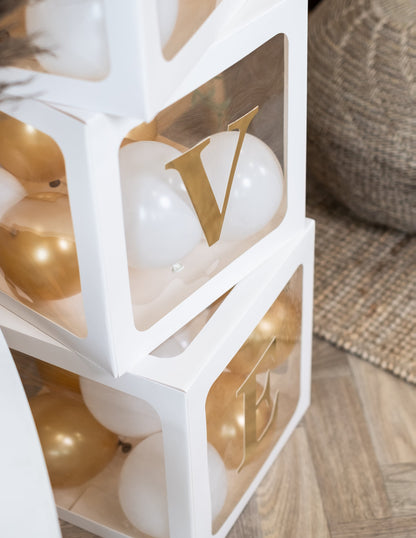 Gros plan sur les lettres V et E des lettres adhésives pour cubes ballons couleur or