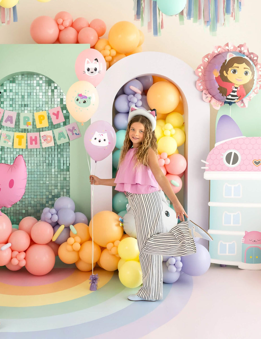 niño sosteniendo los globos de látex Gabby y la casa mágica
