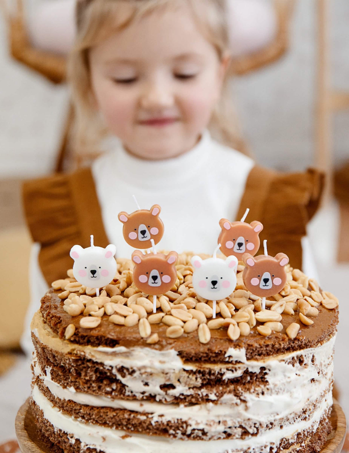 Escena sobre un pastel con velas de cumpleaños y ositos pequeños