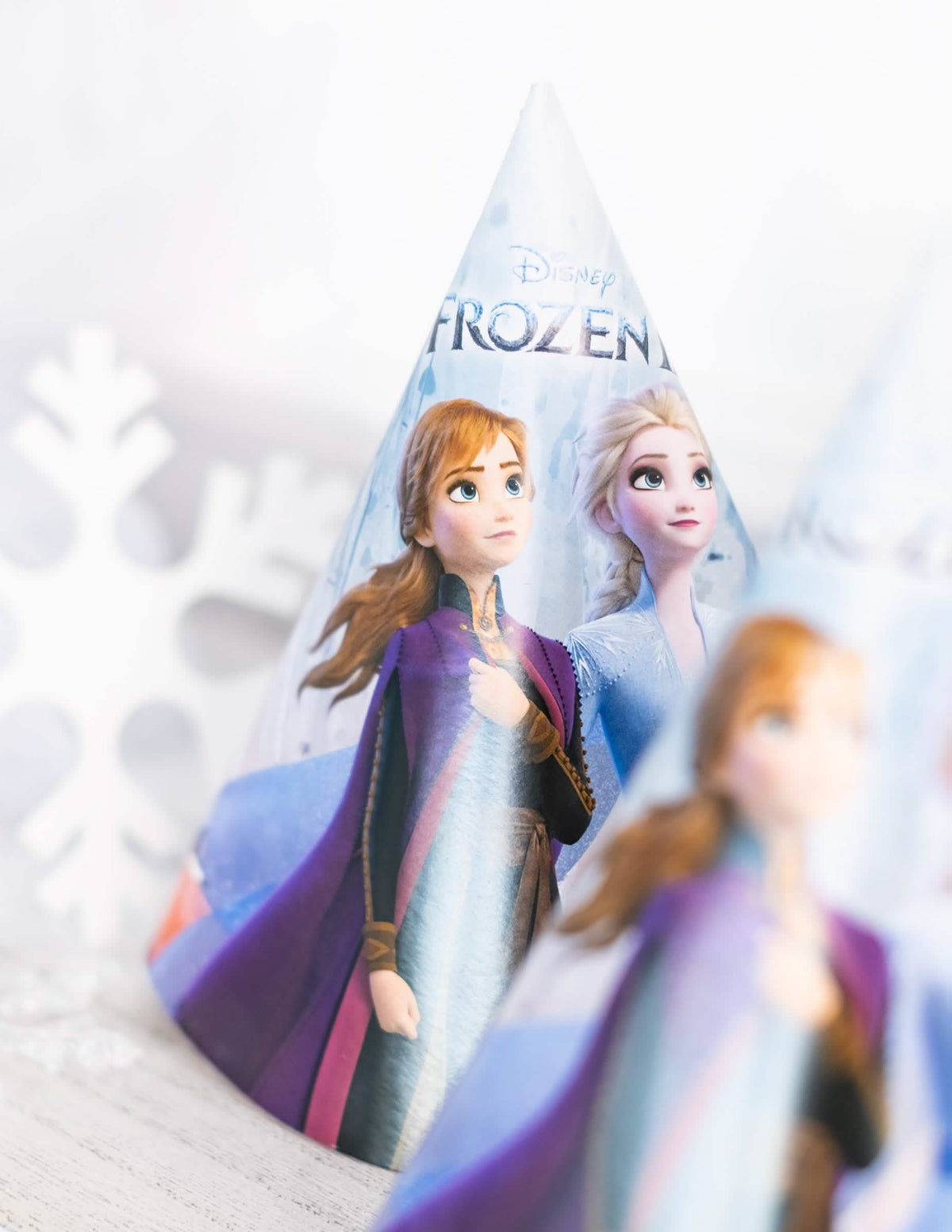 Gros plan sur les personnages Anna et Elsa du chapeau de fête en carton La Reine des Neiges 2