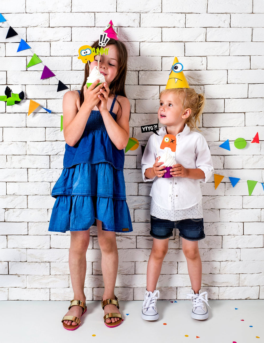 Enfants portant les chapeaux rose et jaune du chapeaux de fête petits monstres