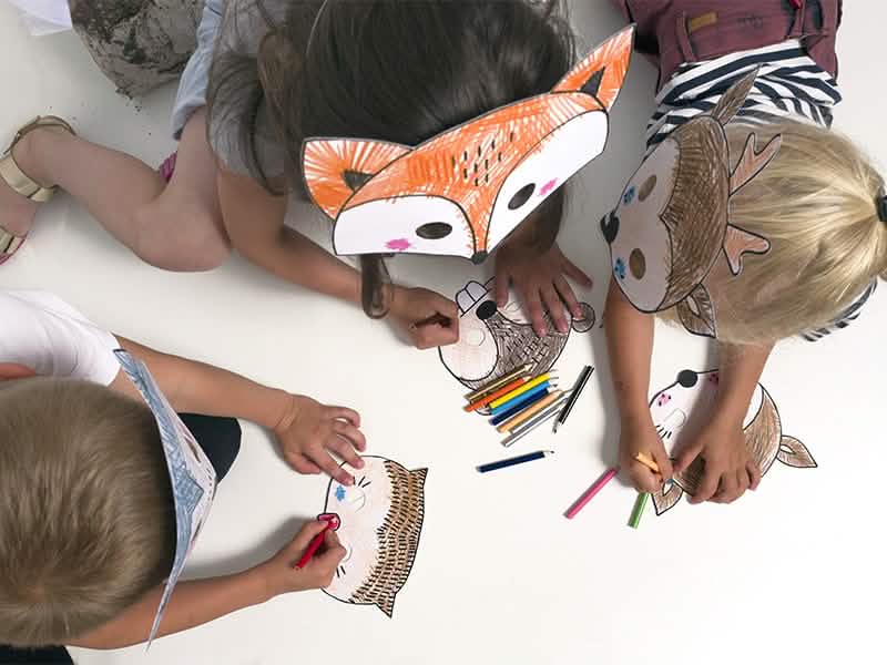 Vue de dessus d'enfants portant les masques à colorier Forêt