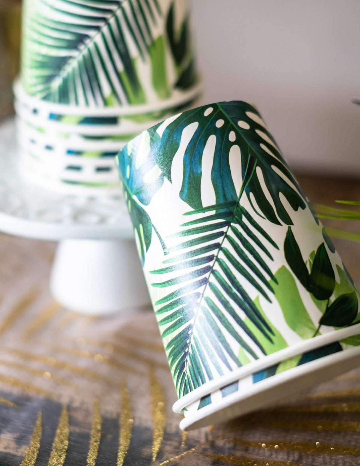 Detalle del motivo de los vasos de cartón tropicales verdes con motivos de hojas de palmera