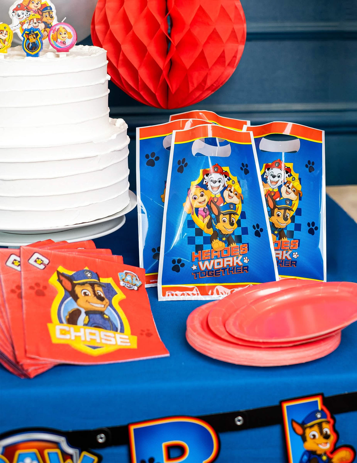 Escena sobre una mesa de fiesta con bolsas de regalo La Patrulla Canina