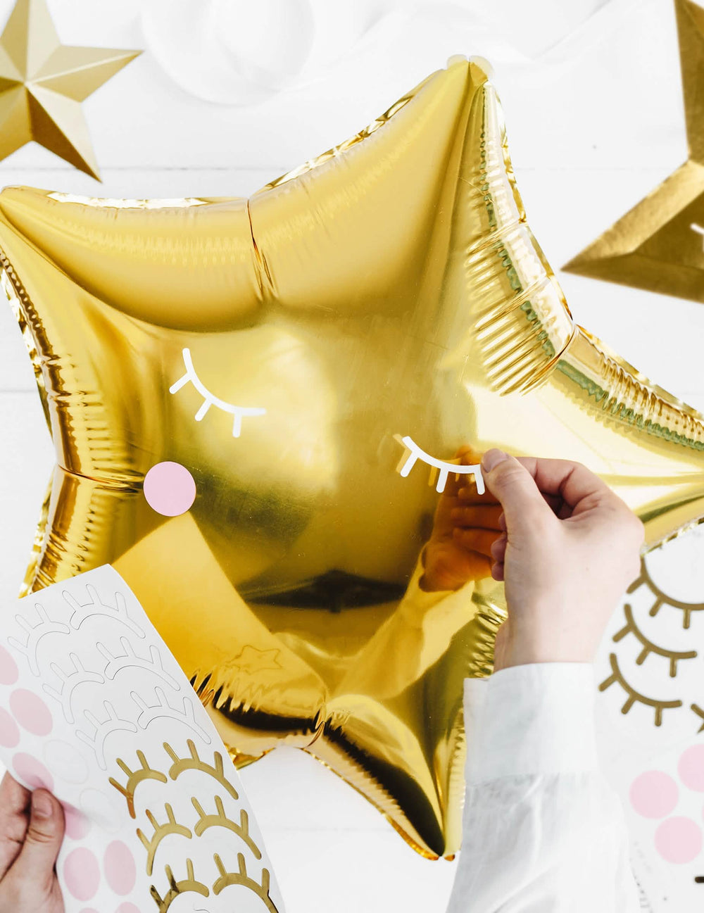 Detalle de la personalización con stickers del globo de aluminio estrella para fiesta dorada