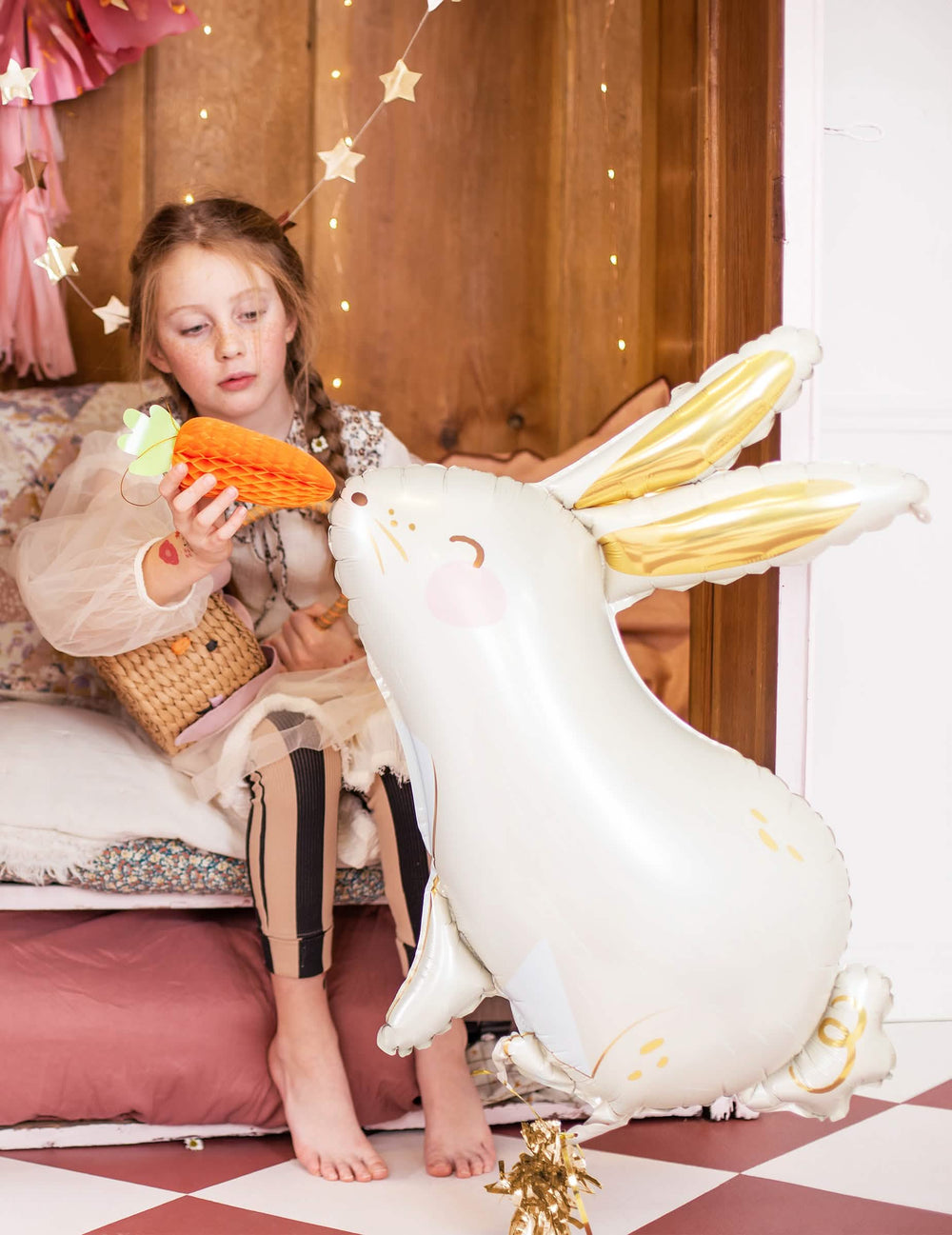 Mise en scène d'une enfant avec une décoration carotte du ballon aluminium lapin pour Pâques