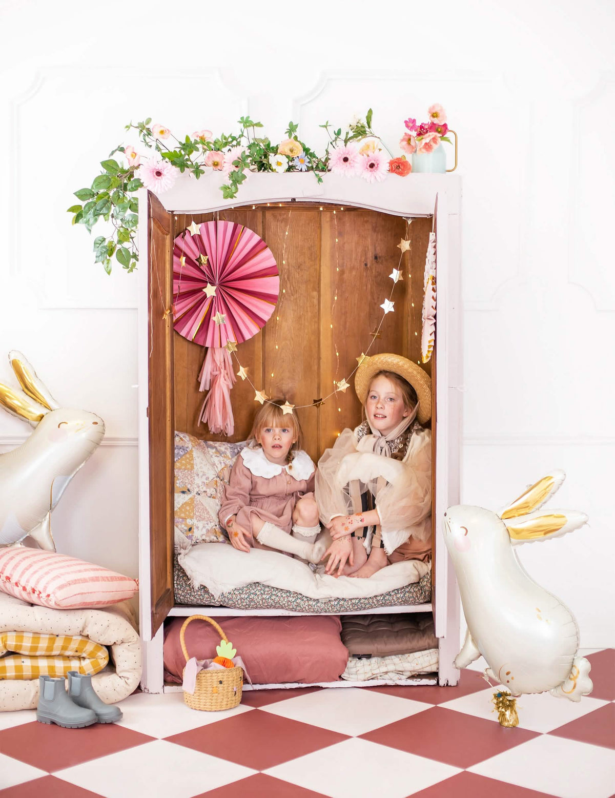Mise en scène de deux enfants dans une armoire décorée du ballon aluminium lapin pour Pâques