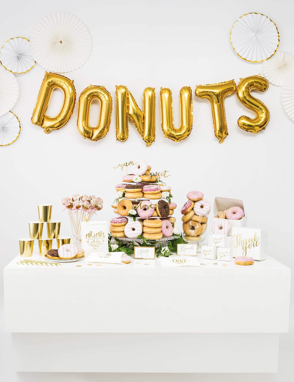 Decoración de candy bar con la palabra DONUTS compuesta por el globo de aluminio letra dorado