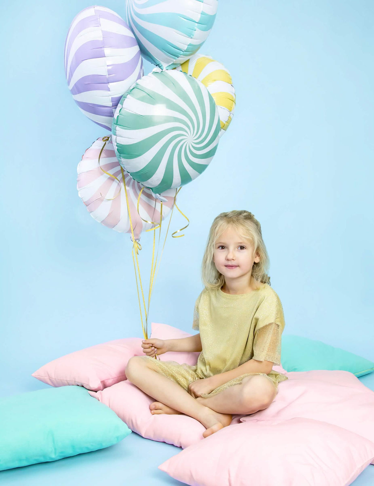 Escenificación del globo de aluminio piruleta para fiesta de menta y blanco en espirales sostenido por un niño