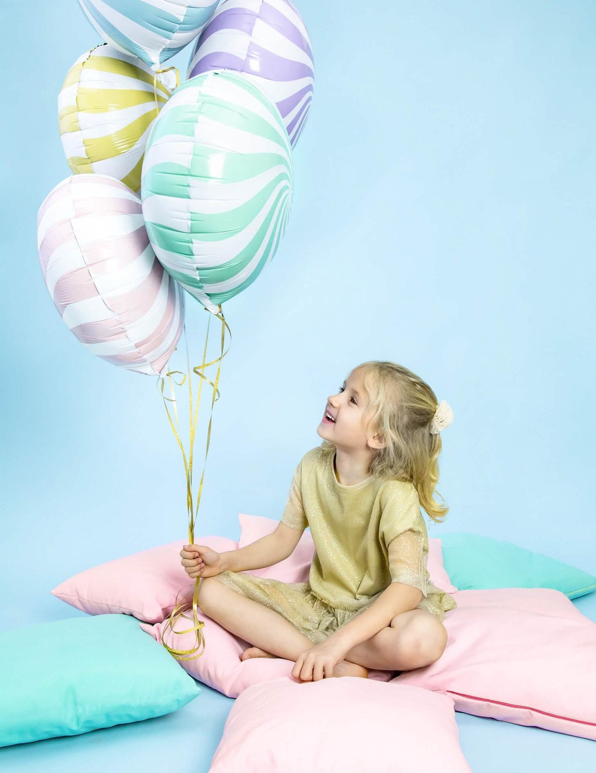 niño sosteniendo el ramo del globo de aluminio piruleta para fiesta turquesa y blanco