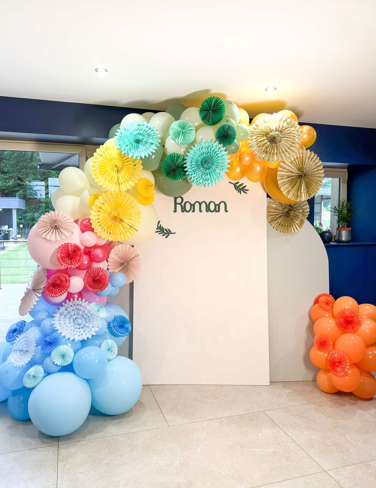 Arco de globos multicolor y rosetones de papel del globo de látex gigante para fiesta azul