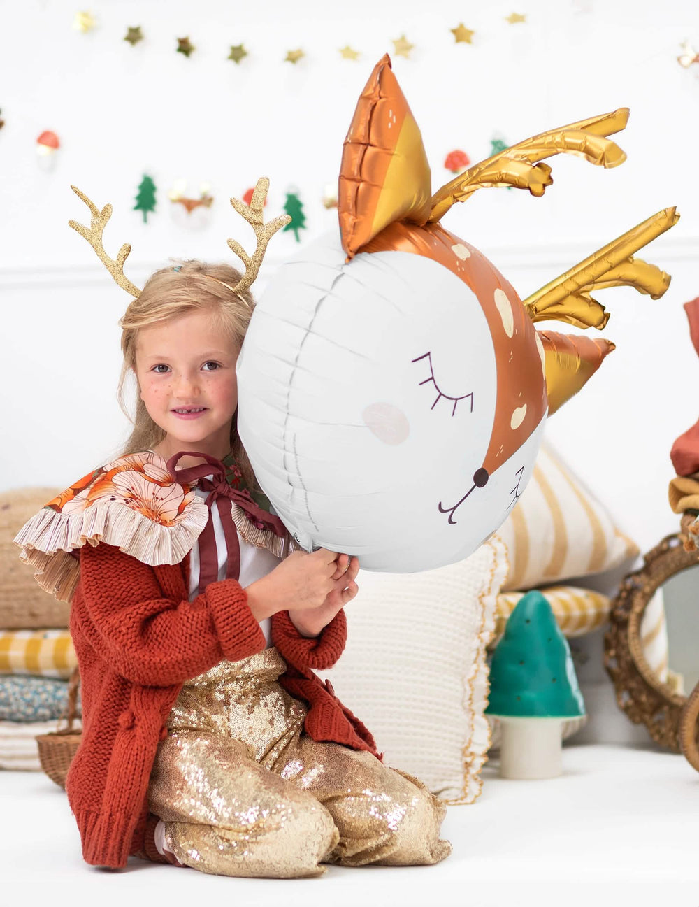 niño sosteniendo el globo gigante de aluminio con cabeza de ciervo