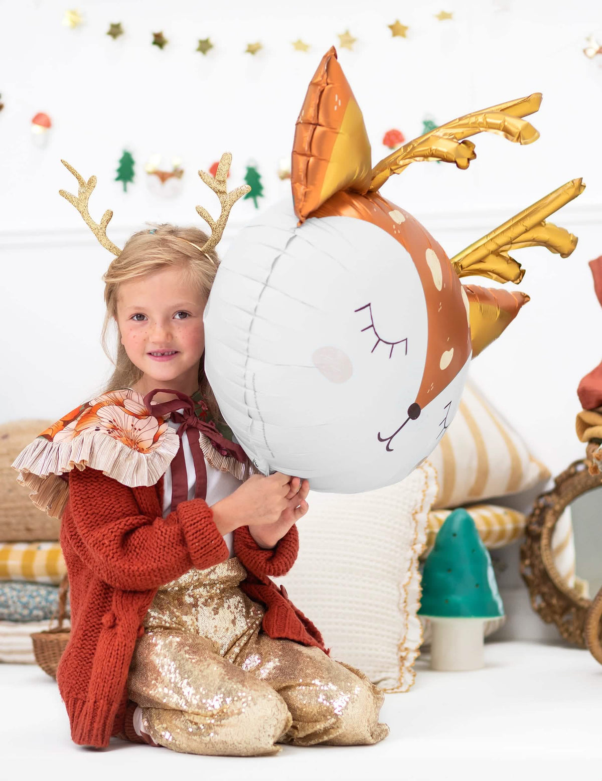 niño sosteniendo el globo gigante de aluminio con cabeza de ciervo