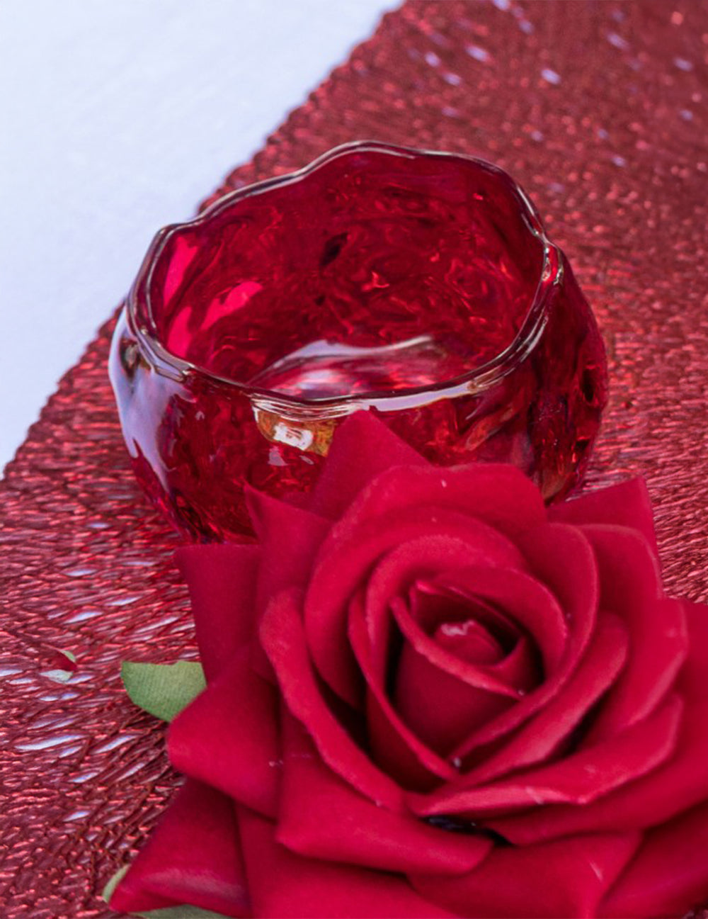 Gros plan du bougeoir en verre en forme de rose rouge