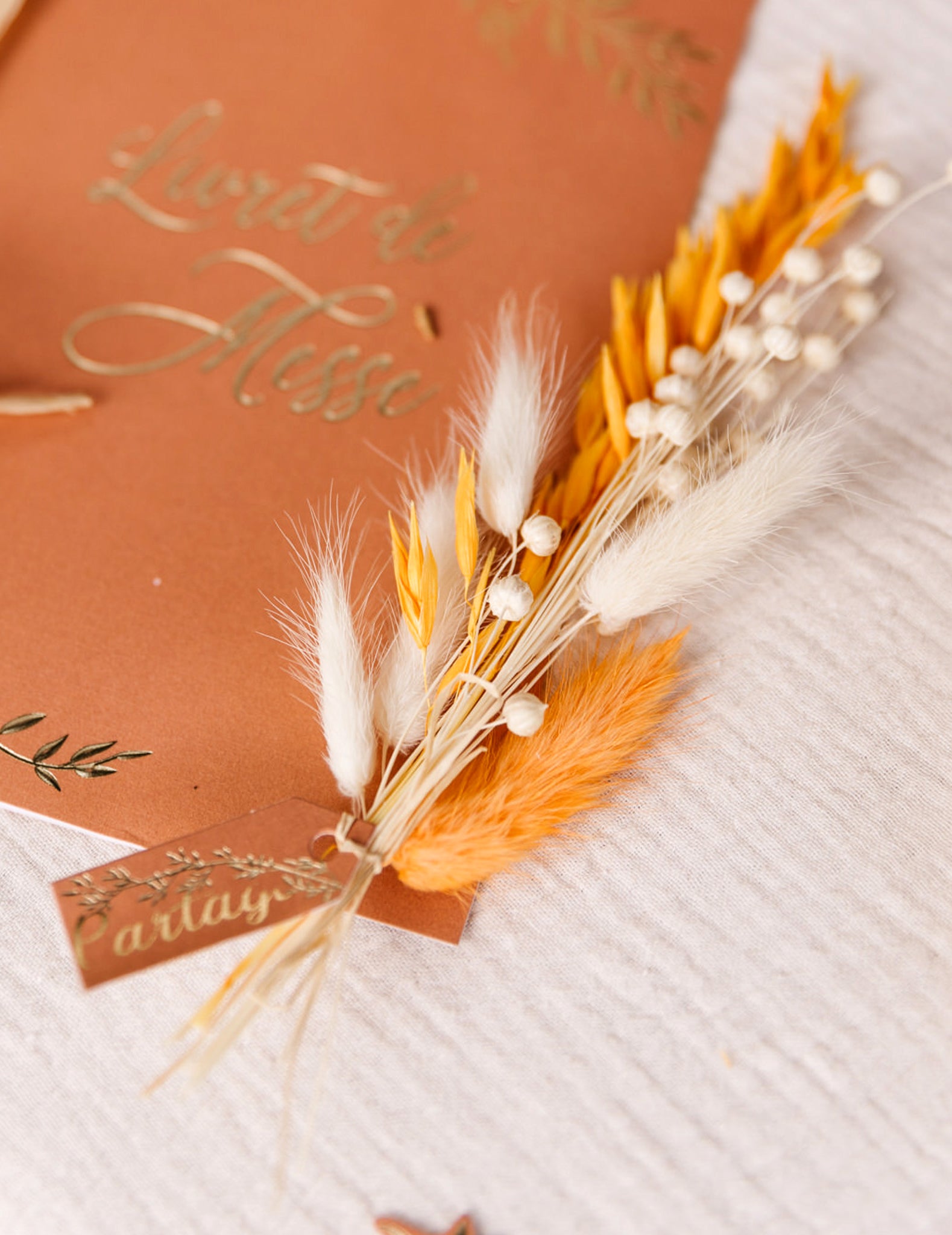 Détail de l'utilisation sur un livret de messe du bouquet de lin séché bohème