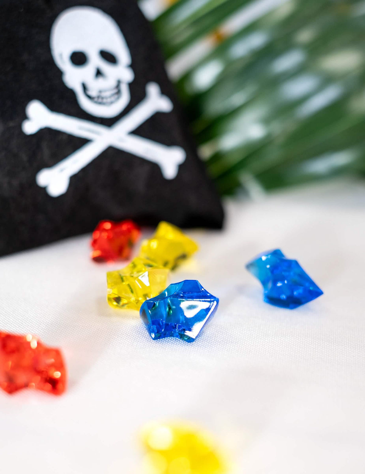 Primer plano de las piedras preciosas multicolores de la bolsa de pirata con falsas piedras preciosas