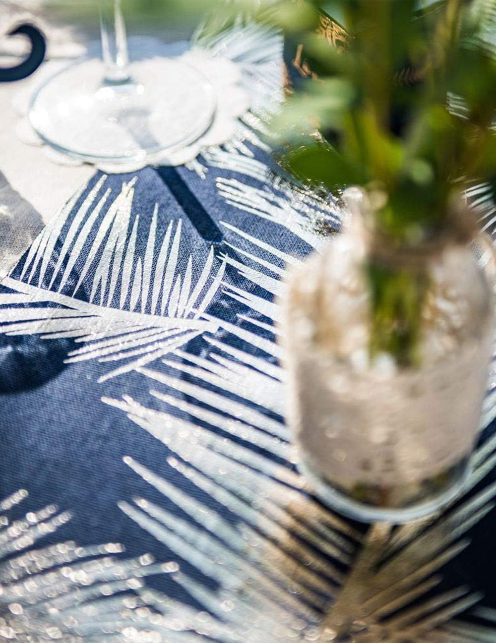 Gros plan sur les motifs dorés du chemin de table chic en lin fougères
